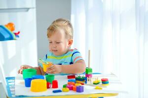 liten pojke 2 år gammal är spelade med en färger leksaker. pedagogisk logik leksaker för barn. montessori spel för barn utveckling. foto