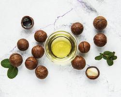 naturlig macadamiaolja och macadamianötter foto