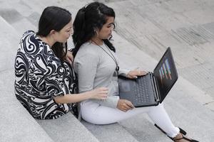 affärskvinnor som arbetar utomhus med en bärbar dator foto