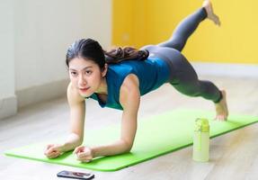 ung asiatisk tjej som gör övning på golvet ensam