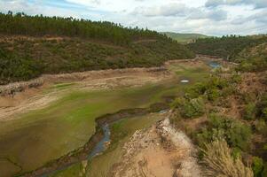 de ponsul flod är en förmögen av de tejo flod, i Portugal, och är en mycket stor flod. på detta tid den är helt och hållet torr, utan vatten och med dess säng knäckt på grund av till klimat förändra foto