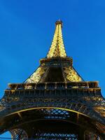perspektiv av de eiffel torn i paris upplyst på de slutet av de dag foto