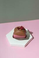choklad-jordgubbe biskvi på en podium på pastell rosa-grön bakgrund. lyx utsökt mat estetik foto