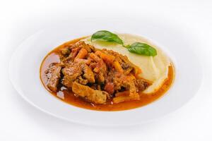 lunch med nötkött bourguignon gryta eras med mosad potatisar på en tallrik foto