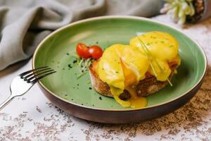 klassisk ägg benedict på grön tallrik foto