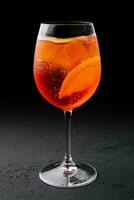 glas av aperol spritz cocktail på svart bakgrund foto