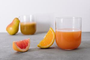 två glasögon av orange och päron juice foto