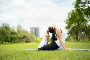 ung kvinna med utomhus- aktiviteter i de stad parkera, yoga är henne VALDA aktivitet. foto