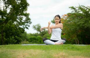 ung kvinna med utomhus- aktiviteter i de stad parkera, yoga är henne VALDA aktivitet. foto