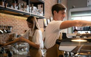 Barista arbetssätt i Kafé. porträtt av ung manlig Barista stående Bakom disken i kaffe affär. foto