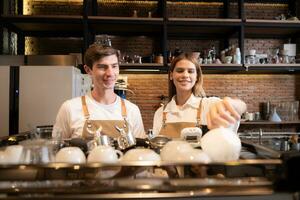 Barista arbetssätt i Kafé. porträtt av ung manlig Barista stående Bakom disken i kaffe affär. foto