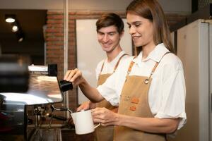 Barista häller kaffe in i en kopp i kaffe affär, närbild foto