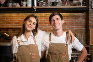 porträtt av en ung manlig och kvinna Barista i en kaffe affär foto