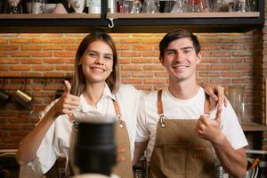 porträtt av en ung manlig och kvinna Barista i en kaffe affär foto