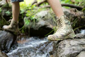 vandring skor på en logga eller stenar i de skog. foto
