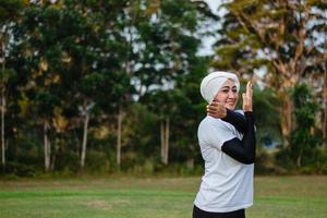 trevlig kvinna i hijab och sportkläder som gör yoga och stretching. foto
