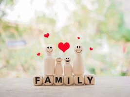 trä- figur av de familj stående på trä- block med de ord familj för Lycklig familj begrepp foto
