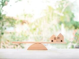 miniatyr- hus på balansering skala för inteckning investering , fast egendom begrepp foto