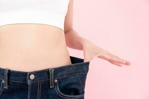 kvinnor som visar resultat av diet. skön form. kvinna ha en nedsatt midja storlek efter under gående en vikt förlust corse. kan inte ha på sig jeans på grund av till vikt förlust. balans, kontrollera, rutiner, träning. foto