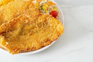 fish and chips med minisallad på den vita plattan foto