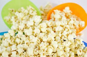 fyra färgrik skålar av popcorn på en vit yta foto