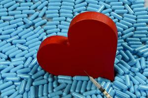 hjärta form och medicin kapslar representerar hjärta problem och behandling foto