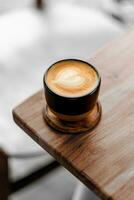 stänga upp kaffe kopp med hjärta form latte konst på trä flik foto