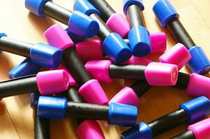 en lugg av blå och rosa plast leksaker på en trä- golv foto