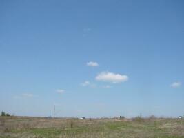 grön fält och blå himmel med ljus moln foto
