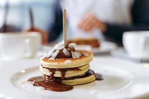 aptitretande pannkakor med kaffe på bordet i ett riktigt kafé. foto