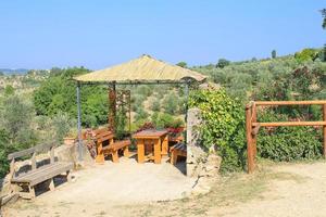 träalkov med bord och bänkar på sommaren i Toscana, Italien