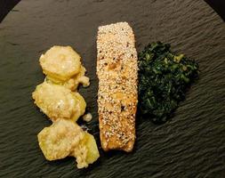 laxbiff med gräddad spenat och bakad potatis foto