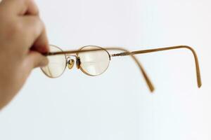 glasögon i en guld ram med dioptrar i hand foto