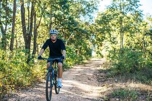 mannen som cyklar i en bergsstig foto