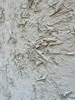 texturerad bakgrund. vägg målad med vit måla. vit vägg är målad med hö och ris sugrör. abstrakt bakgrund med gammal vit plåster. grå Färg bakgrund. vertikal sammansättning foto