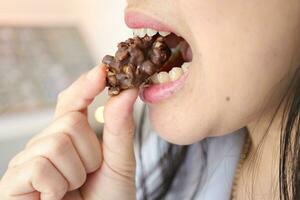 närbild av en kvinnas mun äter mat foto