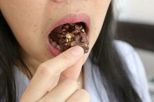 närbild av en kvinnas mun äter mat foto