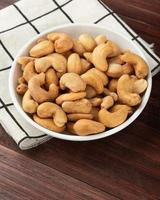 cashewnötter i vit skål på bordet, hälsosamt mellanmål, vegetarisk mat