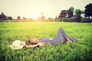 ung vacker kvinna som lyssnar på musik medan du ligger på gräset. foto