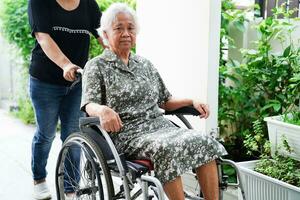 vårdgivare hjälpa asiatisk äldre kvinna funktionshinder patient på vårdsjukhus, medicinsk koncept. foto