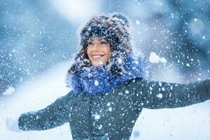 skön leende ung kvinna i värma Kläder. de begrepp av porträtt i vinter- snöig väder foto