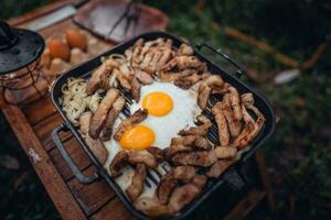 friterad ägg och grillad fläsk i en camping panorera foto