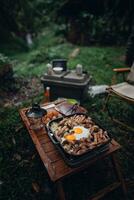 friterad ägg och grillad fläsk i en camping panorera foto