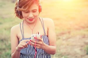 sexig kvinna som använder smartphone för att lyssna på musik med hörlurar foto