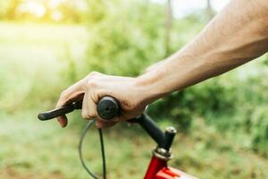 sida se av händer på cykel styre, stänga upp av händer på cykel styret. begrepp av cyklist händer på de styret foto