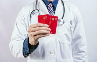 läkare händer innehav kreditera kort. läkare innehav två kreditera kort isolerat. begrepp av medicinsk kort betalningar foto