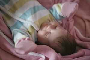 nyfödd bebis sovande på Hem i säng foto