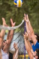 grupp av ung vänner spelar strand volleyboll foto