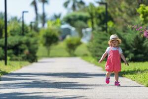 liten flicka springer i sommarparken foto