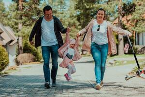 familj roligt i de parkera. Lycklig familj utgifterna tid i parkera och spelar med deras dotter foto